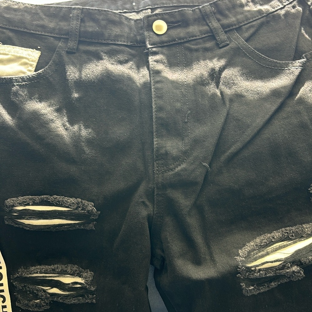 Designer pants with zippers- straps and rips..